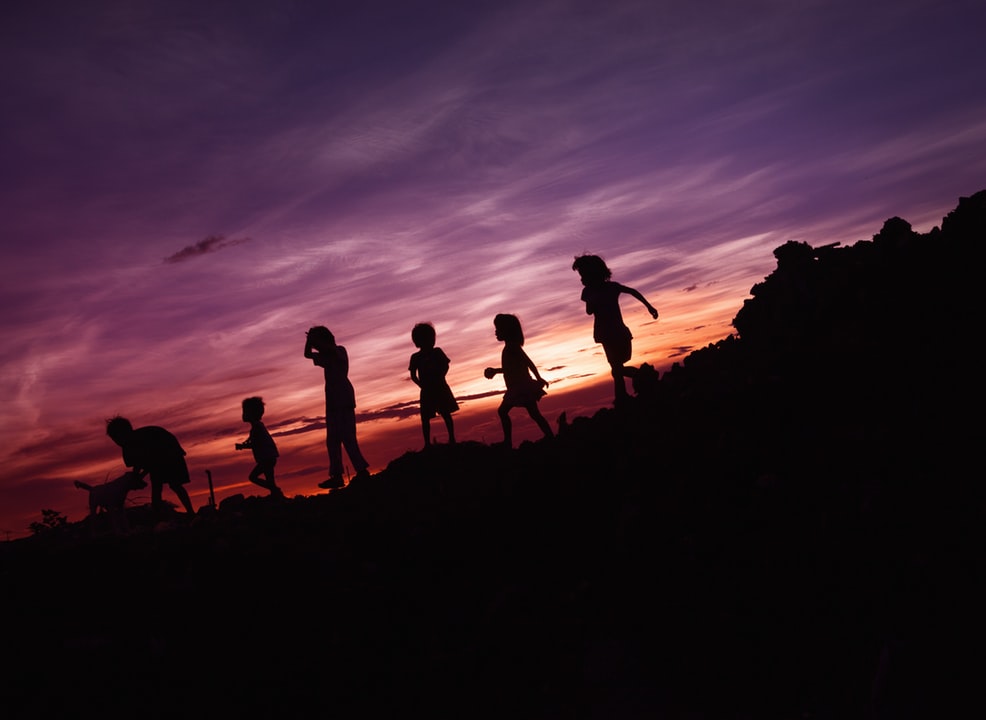 Kids playing with their dog during sunset. Photo by Rene Bernal on Unsplash 